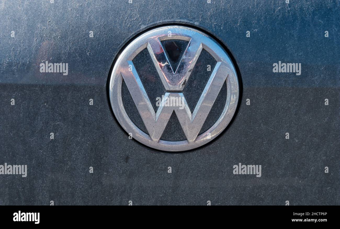 Dirty VW (Volkswagen) logo on a black car. Volkswagen is a company of the Volkswagen Group. Stock Photo