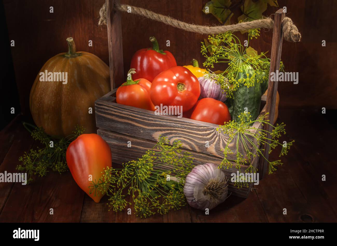fresh vegetables in a box on a dark wooden background in a rustic style ...