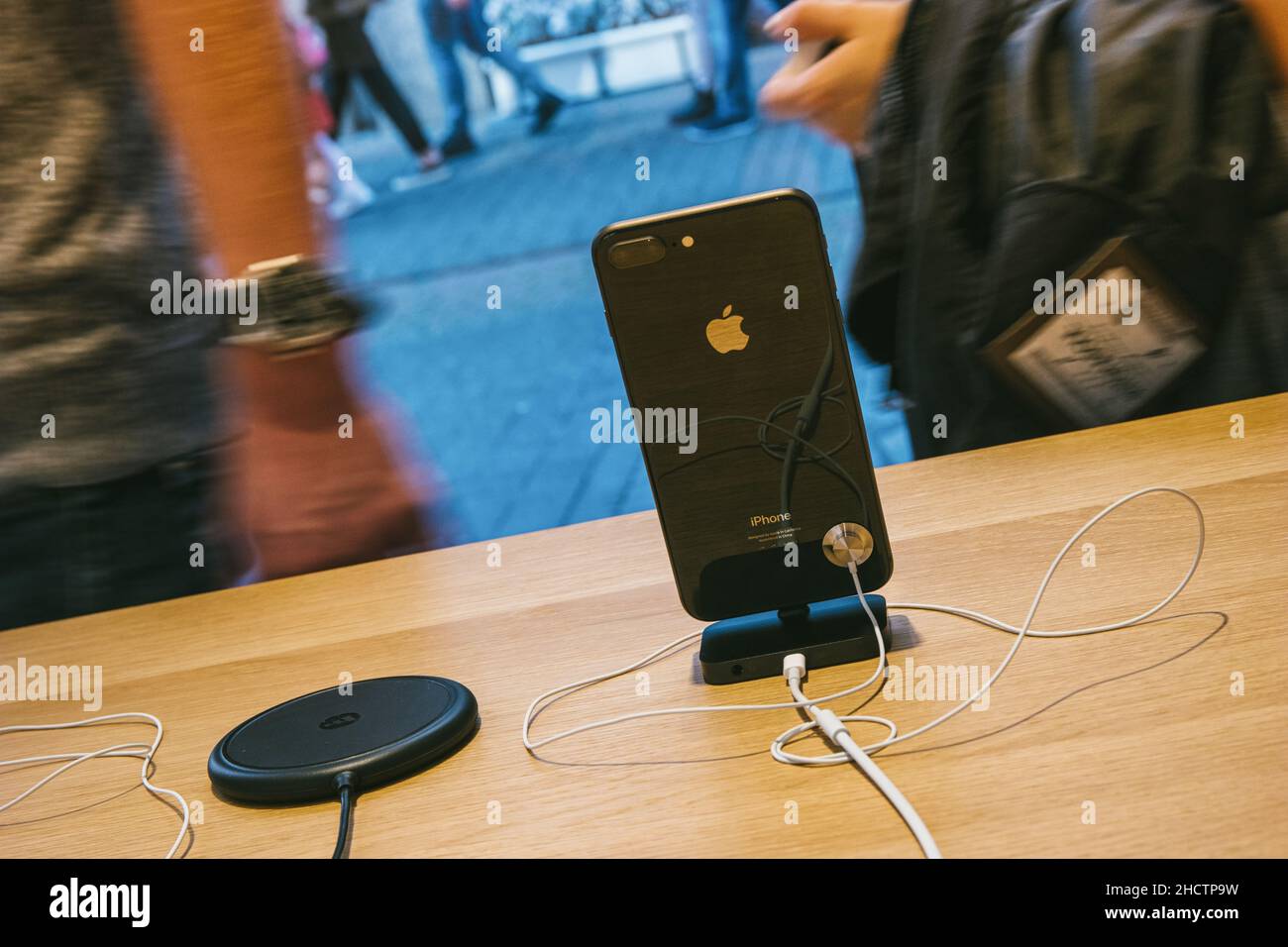presentation of the iPhone 8 and  Phone X in a Apple Store with reflection of street in glass facade with phones inside next to AirPower wireless char Stock Photo