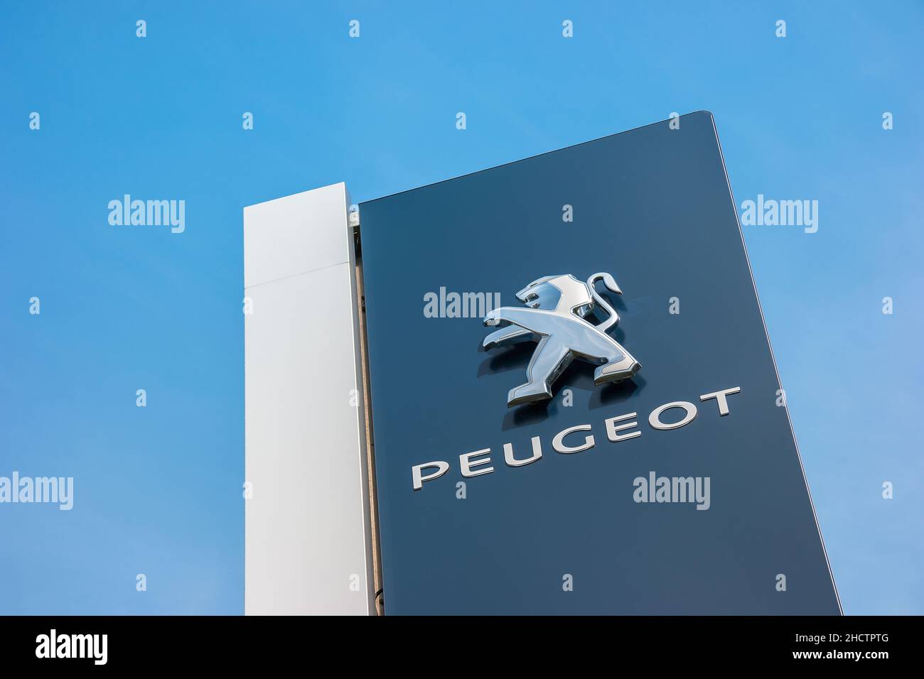 Peugeot dealership sign closeup against blue sky. Peugeot is a French automobile manufacturer and part of Groupe PSA. Stock Photo