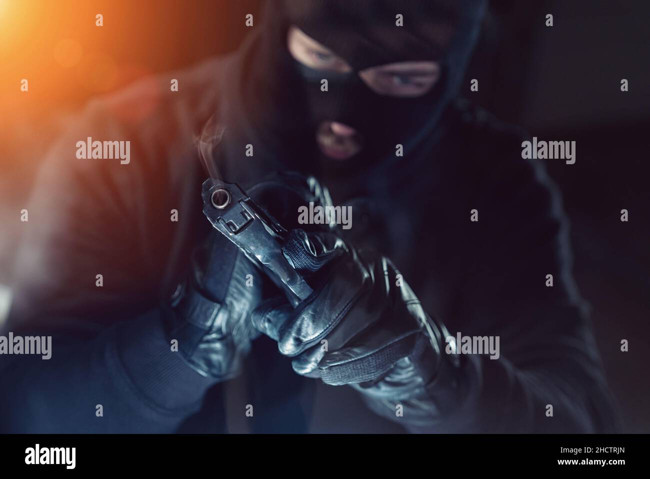 Terrorist or a thief holding a gun at night Stock Photo