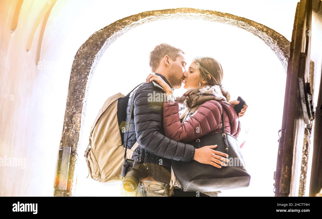 Travel couple in love kissing outdoors at city tour excursion - Young happy tourists enjoying romantic moment at sunset - Relationship concept Stock Photo