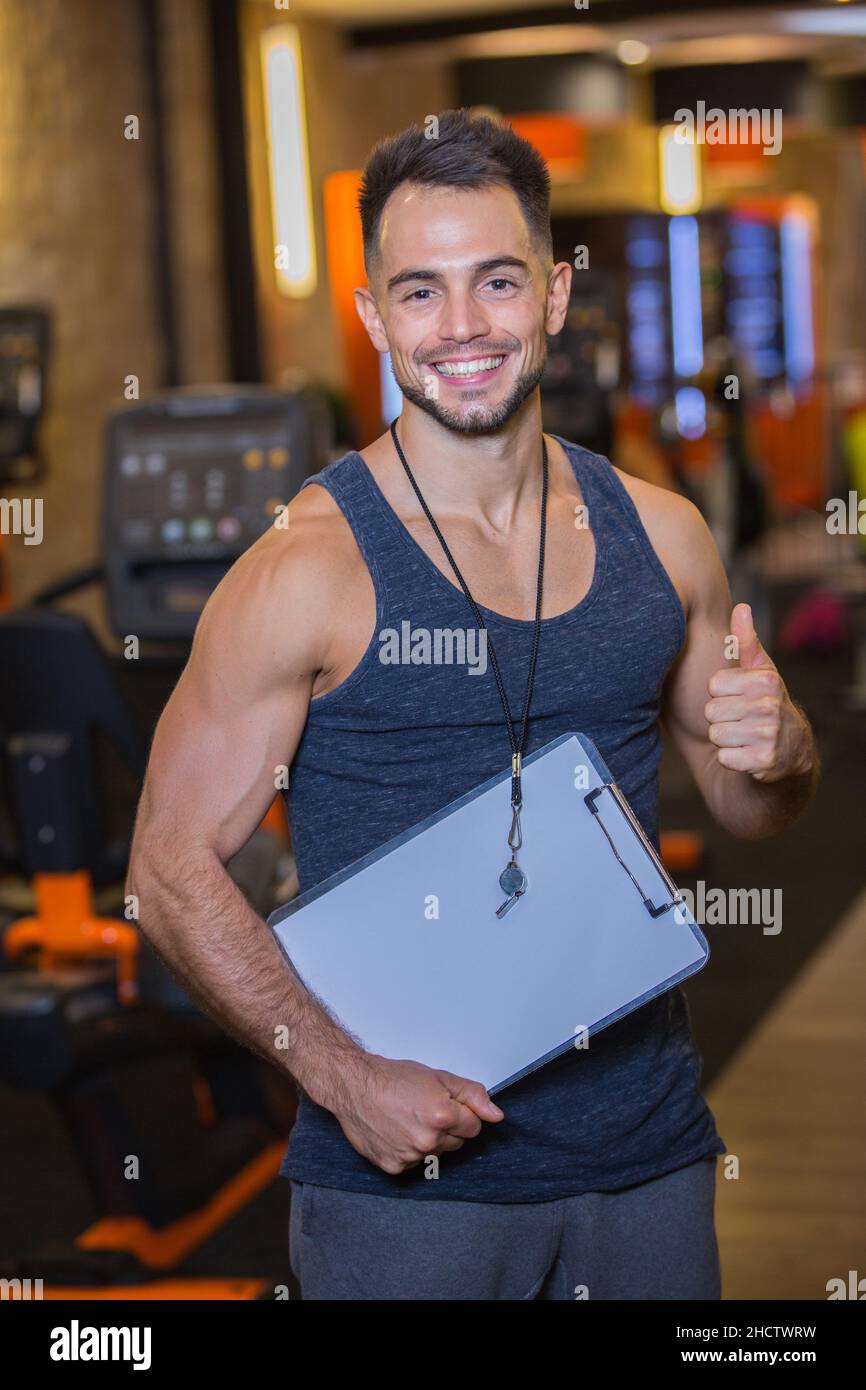 happy personal trainer with clipboard doing thumb up gesture Stock ...