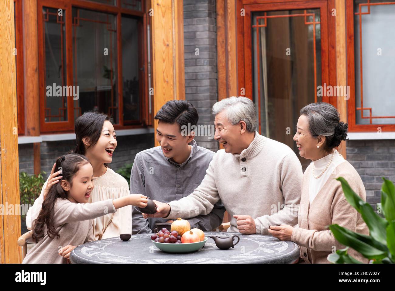 Happy families drinking tea and chatting in the courtyard Stock Photo