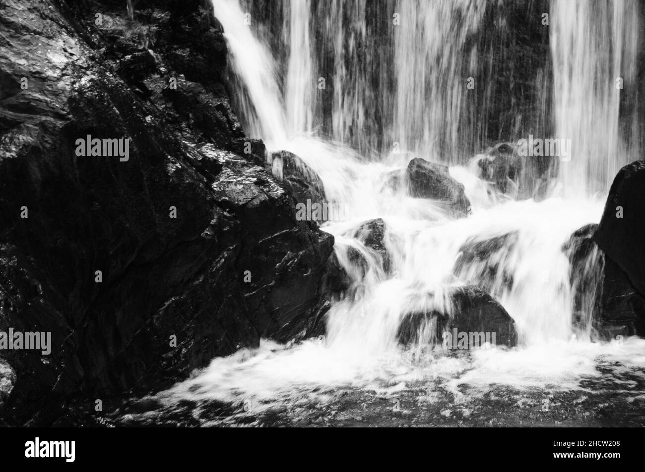 Black and white image of water falling steep on stones in Bad Eisenkappel, Völkermarkt, Carinthia, Austria Stock Photo
