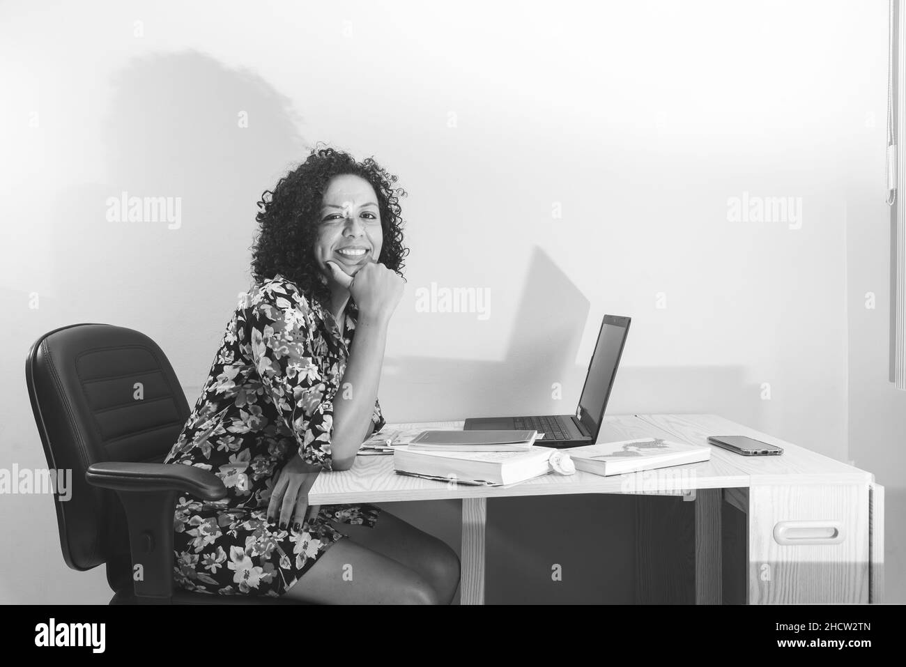 Black and white portrait of a woman sitting working remotely from her home. Salvador, Bahia, Brazil. Stock Photo