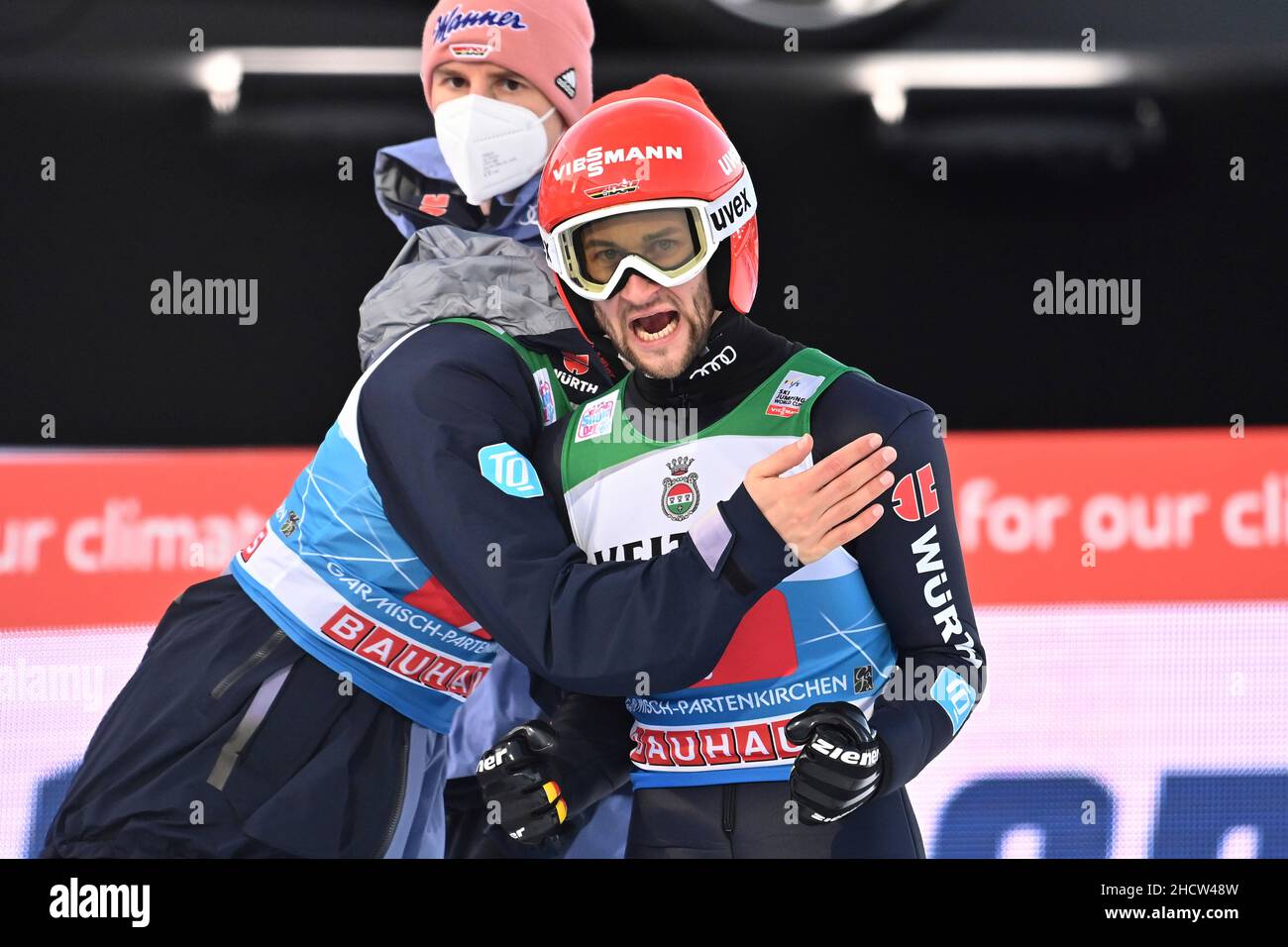 Markus EISENBICHLER (right, GER) with Stephan LEYHE (GER), back: Karl GEIGER (GER), jubilation, joy, enthusiasm, action, ski jumping, 70th International Four Hills Tournament 2021/22, New Year's jumping in Garmisch Partenkirchen, Olympic hill on 01.01. 2022 Stock Photo