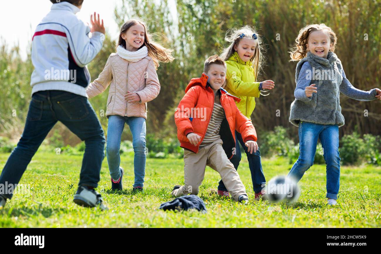 Happy kids playing football outdoors Stock Photo - Alamy
