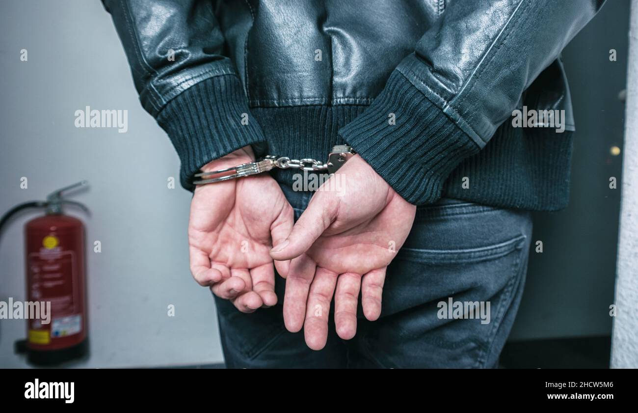 Burglar hands locked in handcuffs Stock Photo