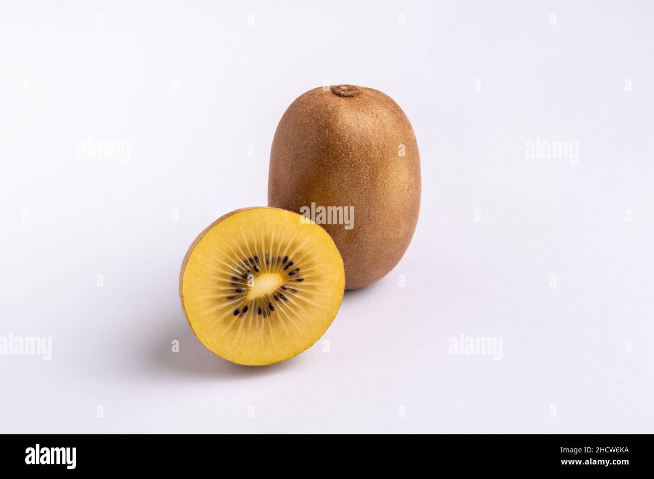 Whole and half of yellow or gold kiwi fruit isolated on white, horizontal Stock Photo