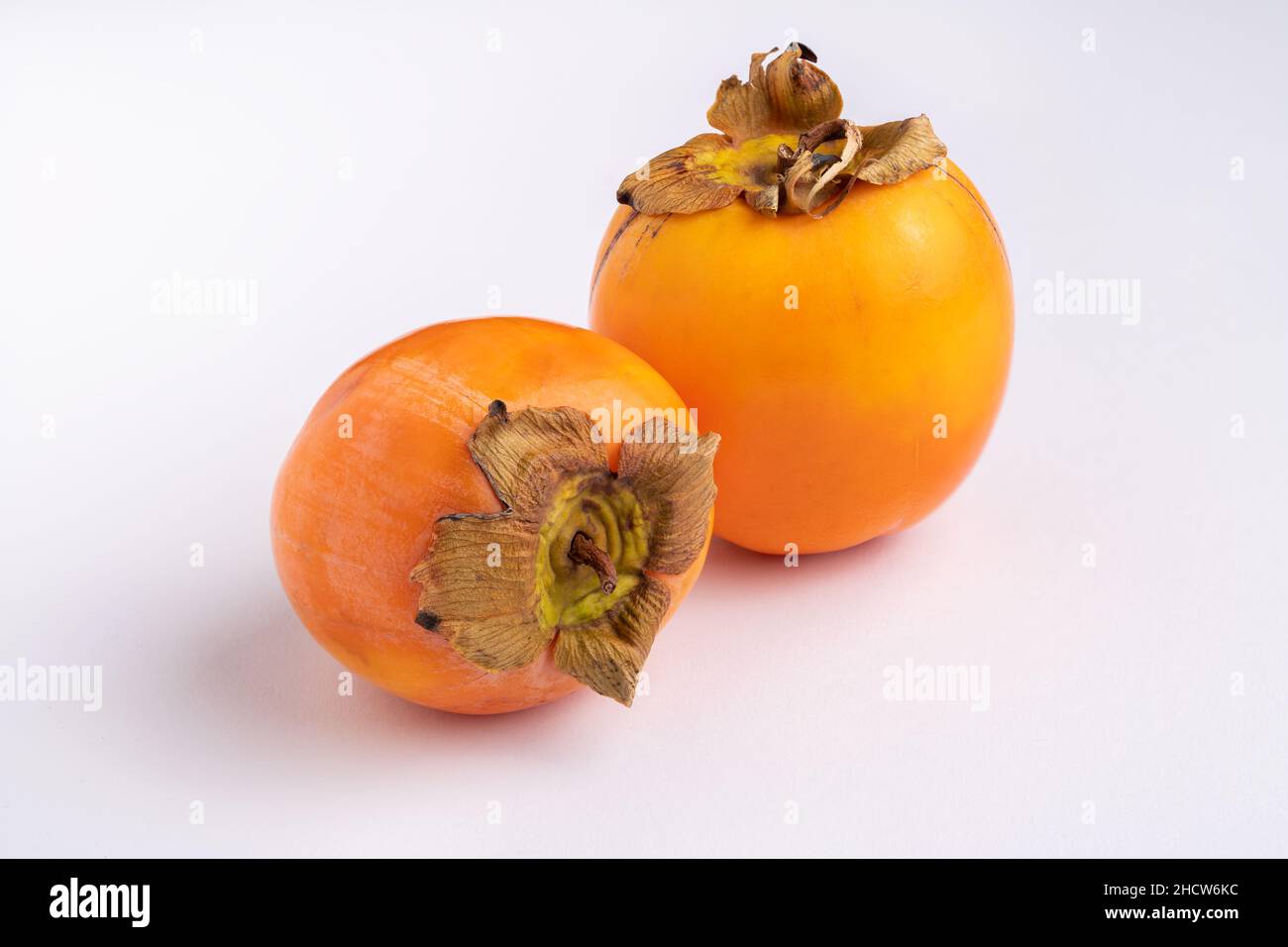 Two fresh persimmons isolated on white background, space for text Stock Photo