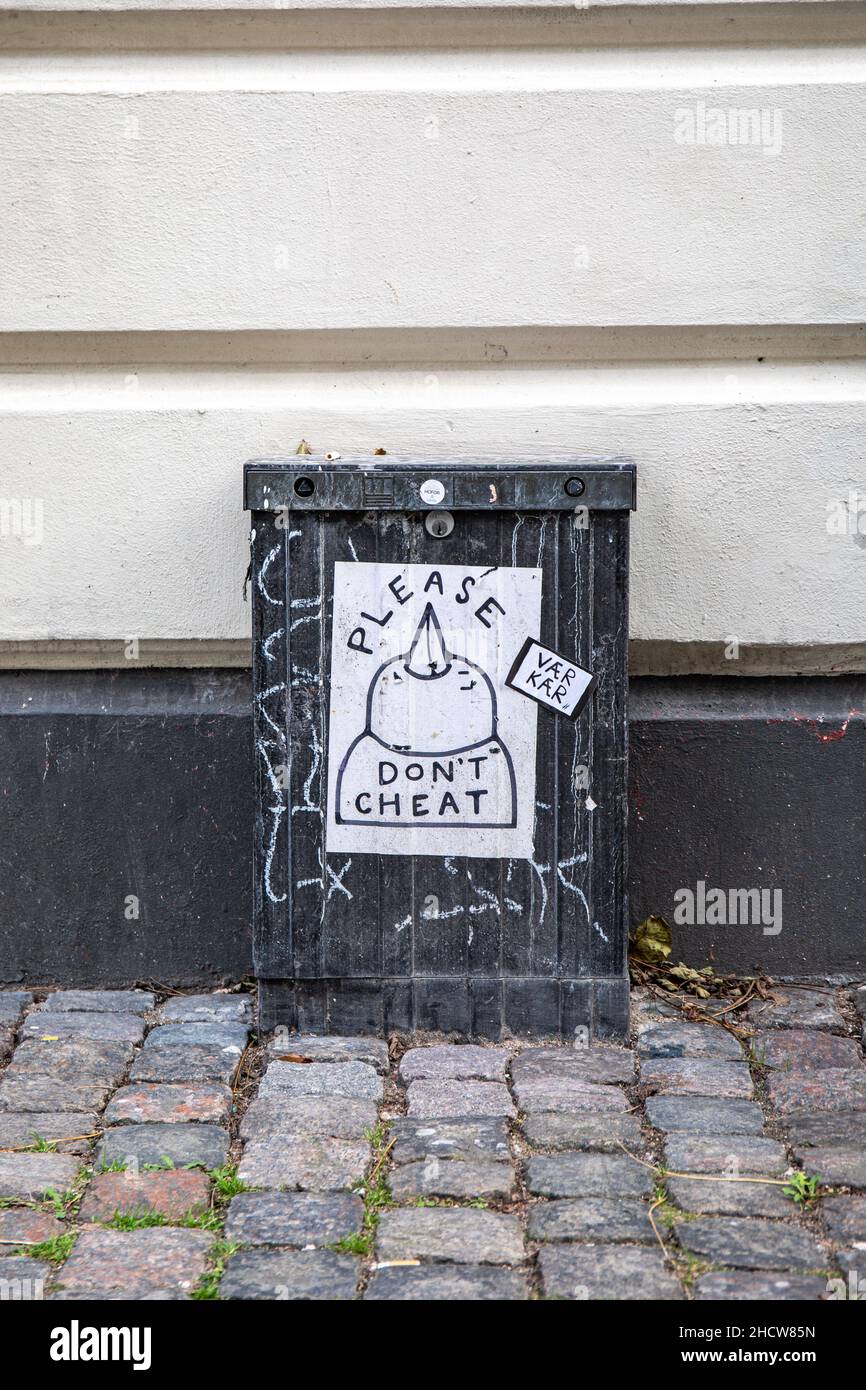 Please don't cheat. Street art poster in Vesterbro district of Copenhagen, Denmark. Stock Photo
