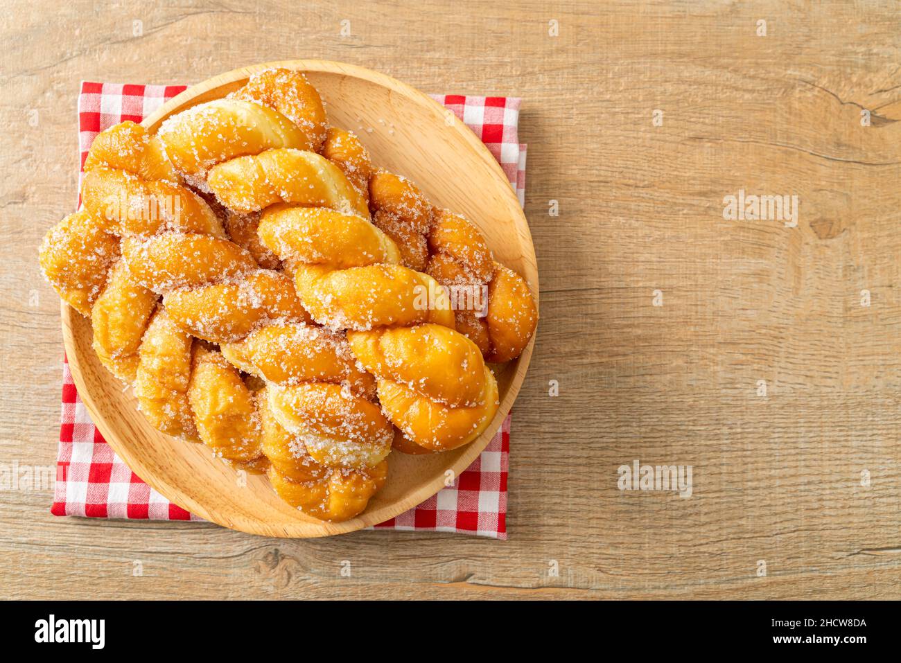 sugar doughnut in spiral shape on wooden plate Stock Photo