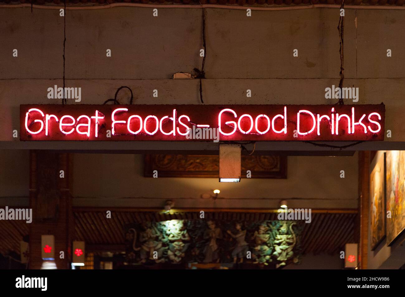 Pink neon light above a restaurant saying Great foods - Good drinks. Stock Photo