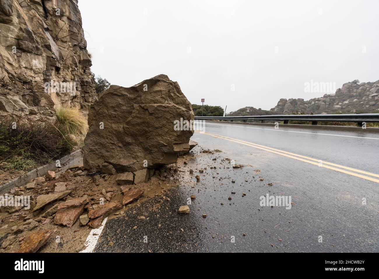 Landslide boulder blocking traffic lane on Santa Susana Pass Road in the Chatsworth area of Los Angeles, California. Stock Photo