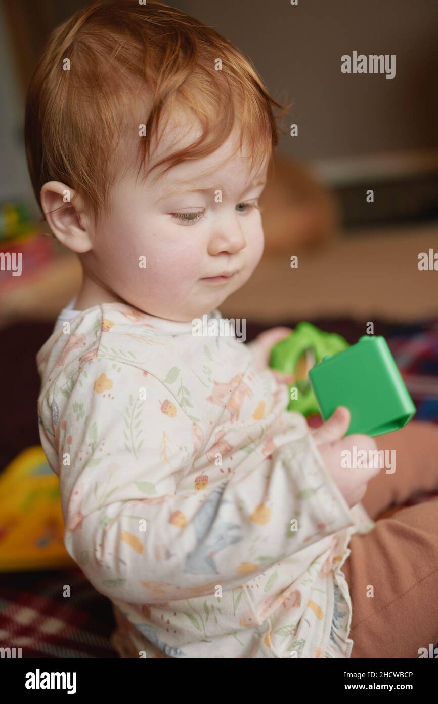 A ten-month old red headed baby girl with toys Stock Photo - Alamy