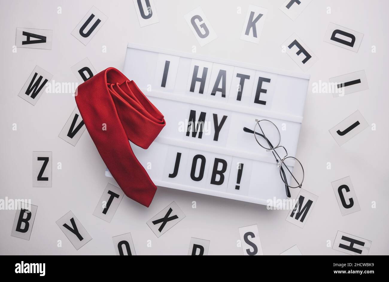 Lightbox with words I Hate My Job and office glasses with red tie, business concept image Stock Photo