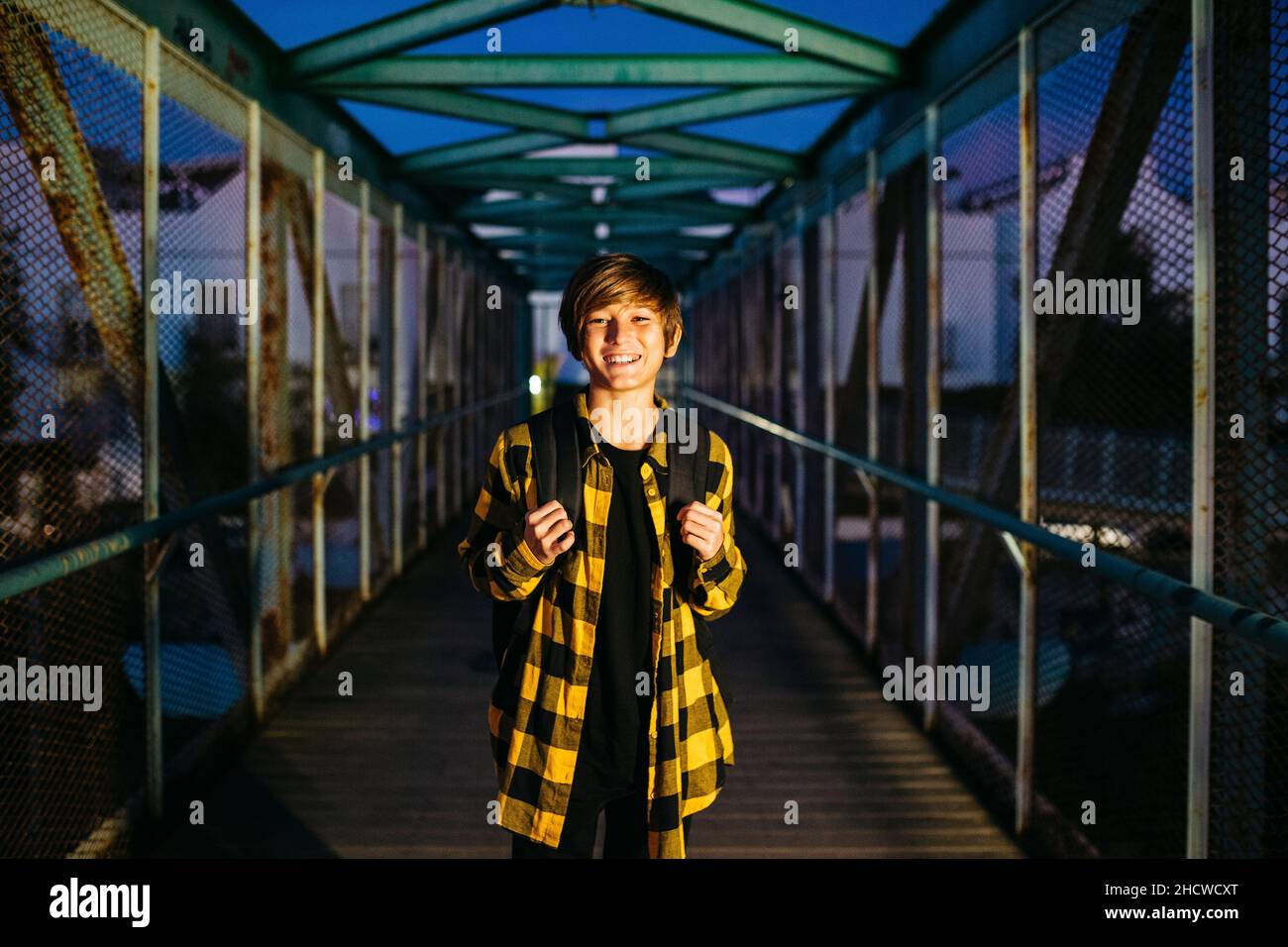 Portrait of a Teenager boy on an old metal bridge on his way to school Stock Photo