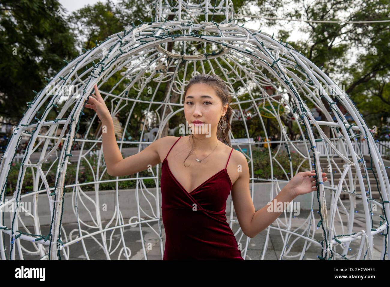 Portrait of Young Asian Woman Inside a Large Christmas Ornament Sculpture Stock Photo