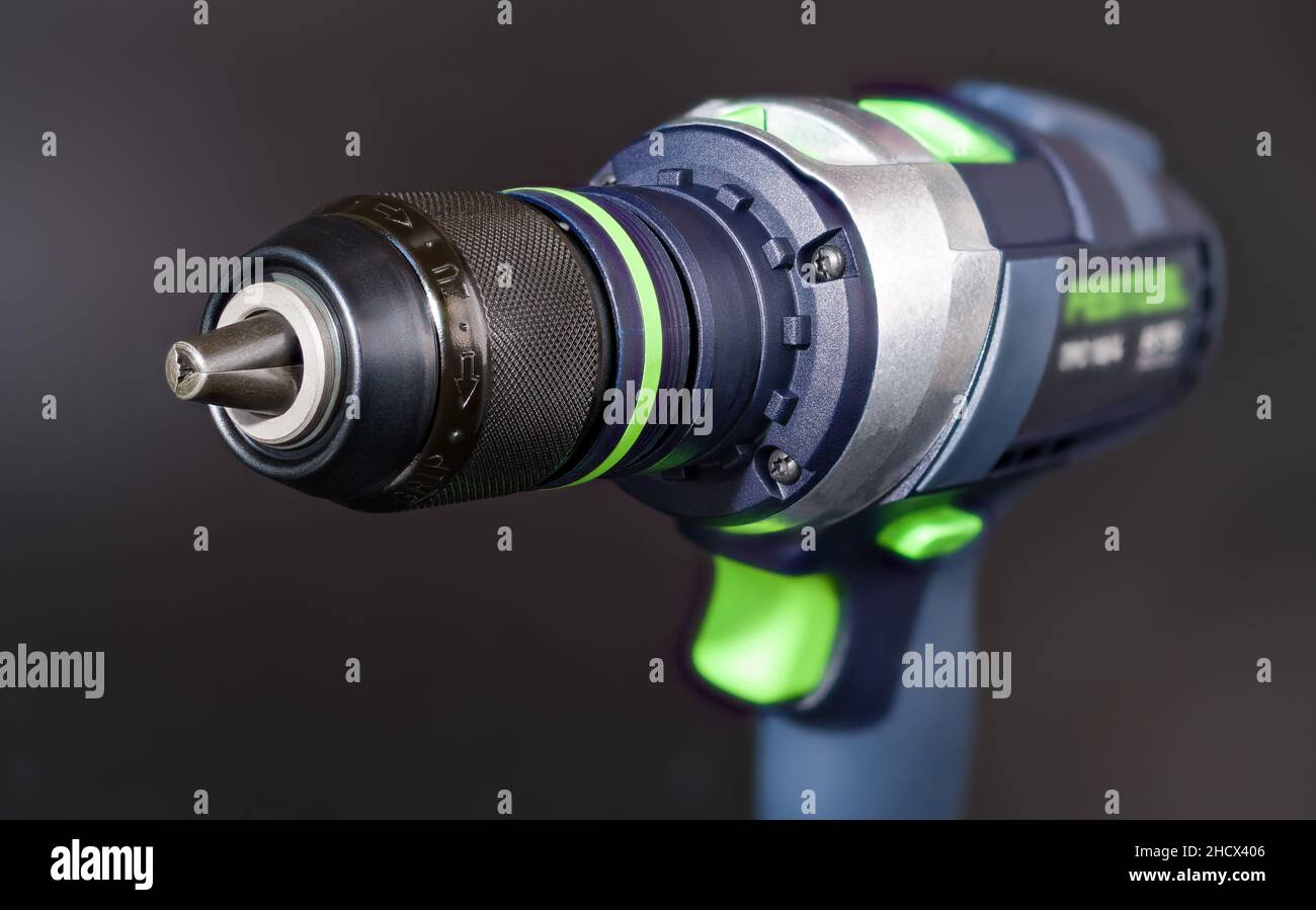 Cordless screwdriver on dark gray blur background. Jaws detail of quick-release chuck. Professional electric tool as screw gun or power drill machine. Stock Photo