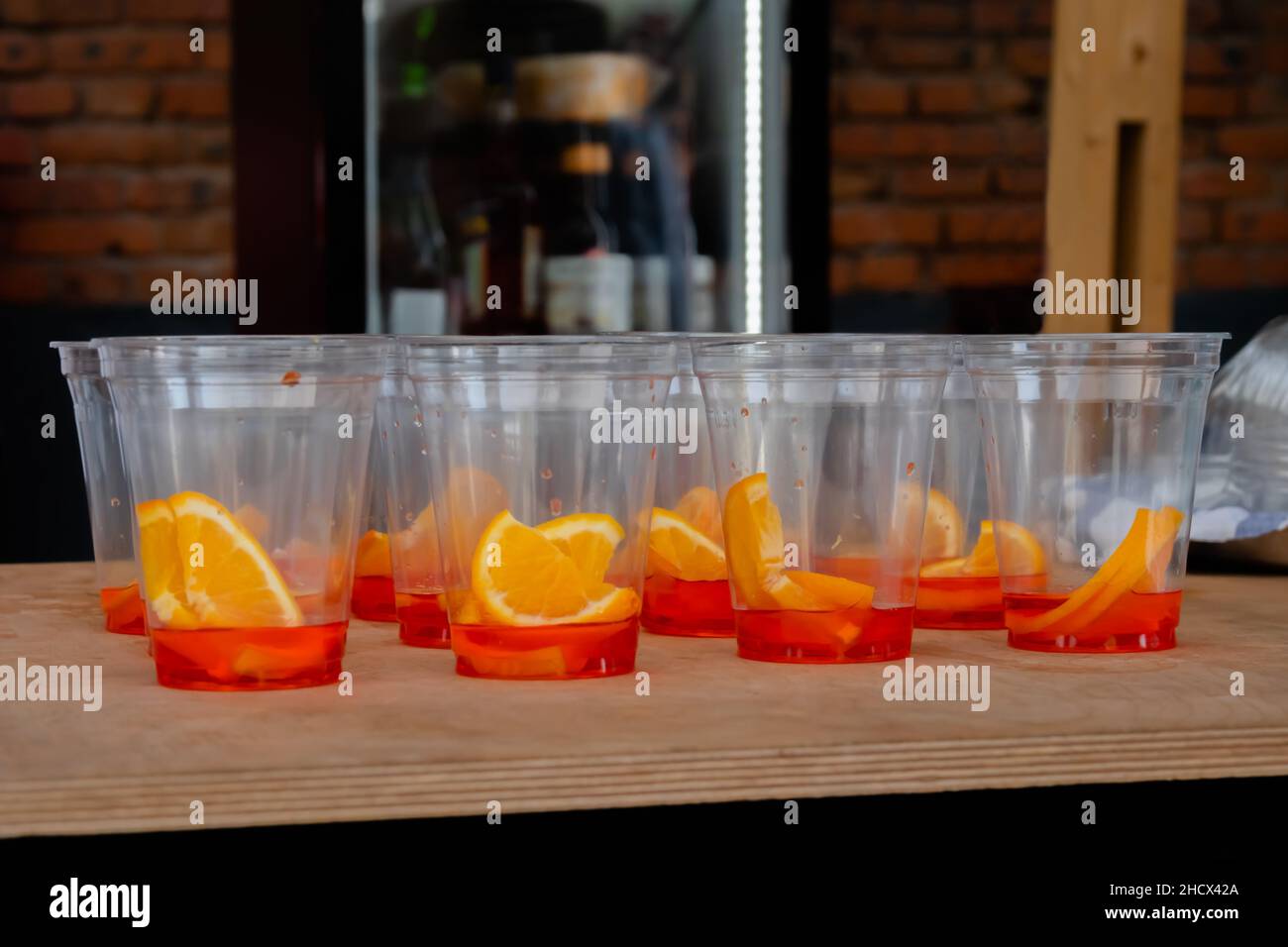 Plastic cups with orange slices and Spritz Aperol cocktail on counter -  close up Stock Photo - Alamy