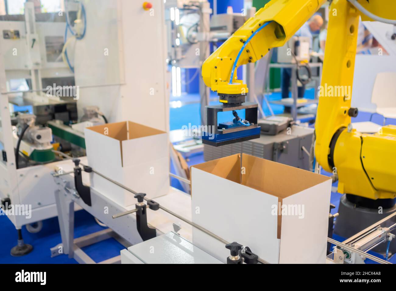 Yellow robotic arm manipulator working with cardboard boxes - sorting ...