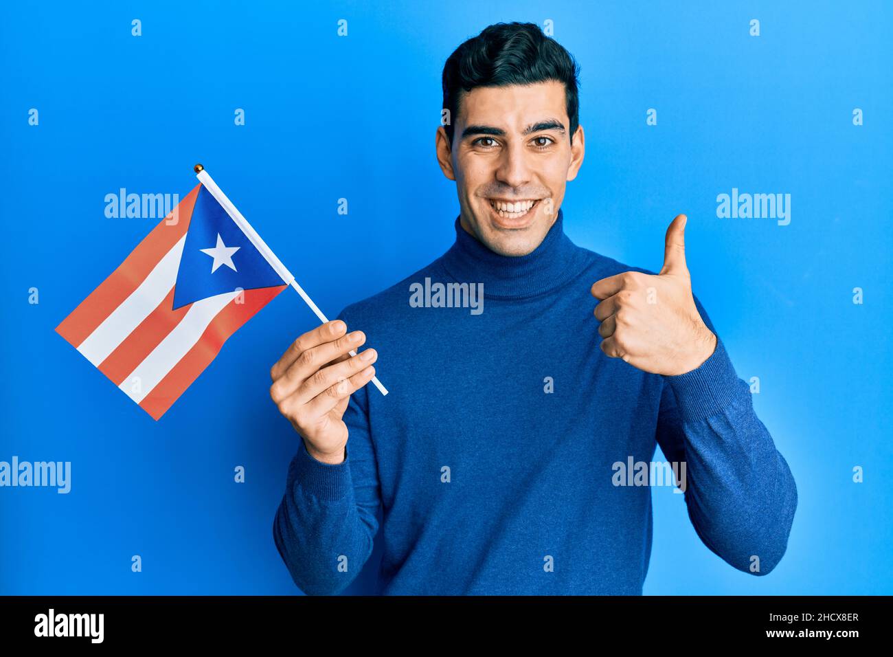 Handsome hispanic man holding puerto rico flag smiling happy and ...