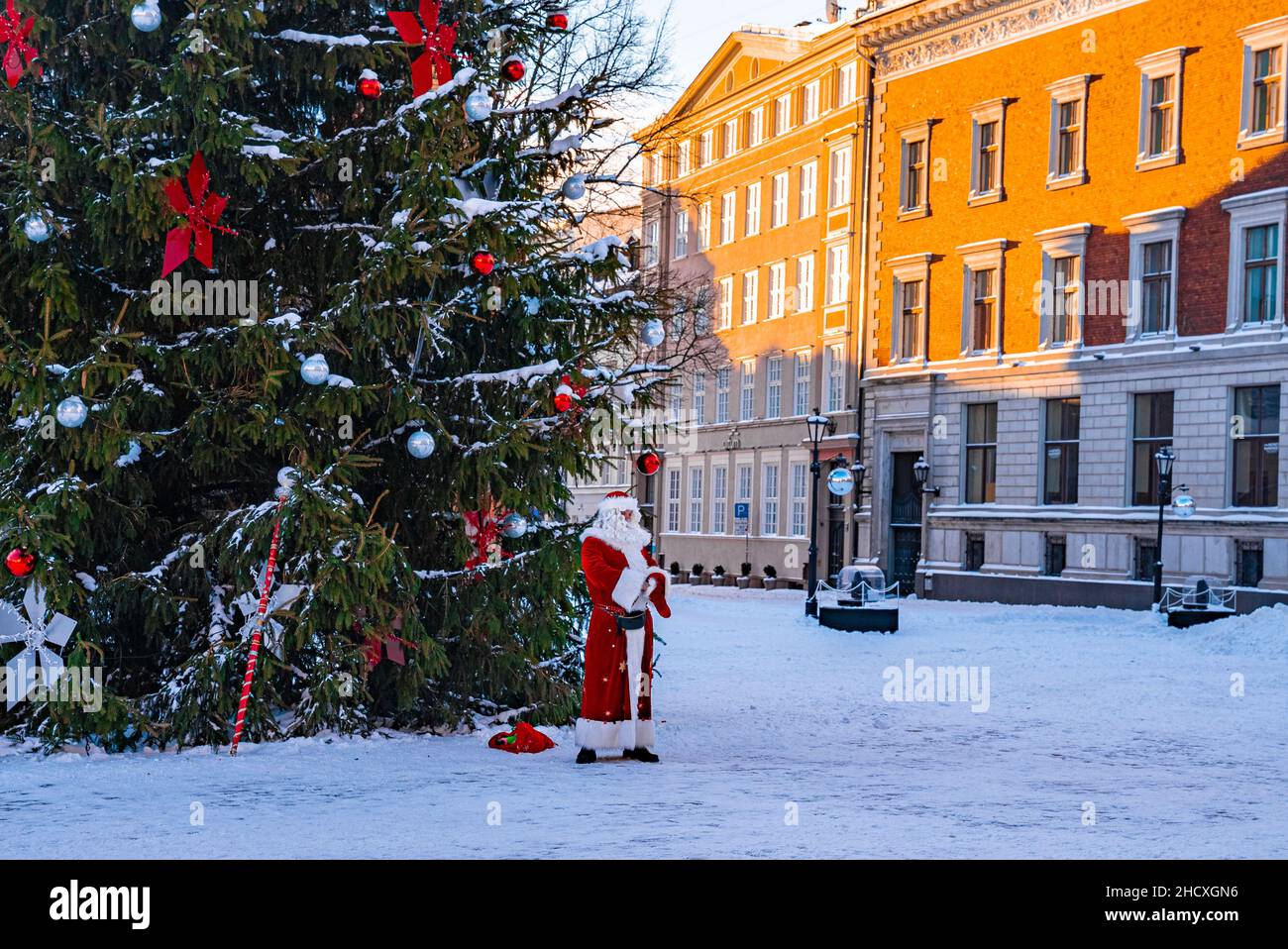 Santa Claus walking by the huge Christmas tree in Riga, Latvia. Stock Photo