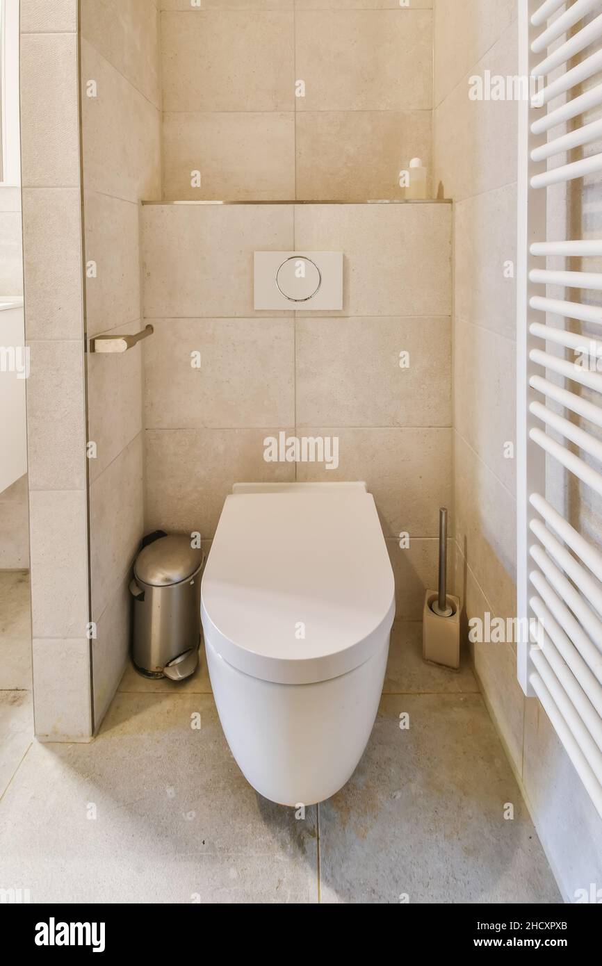 Magnificent bathroom in beige tones with a toilet next to the radiator Stock Photo