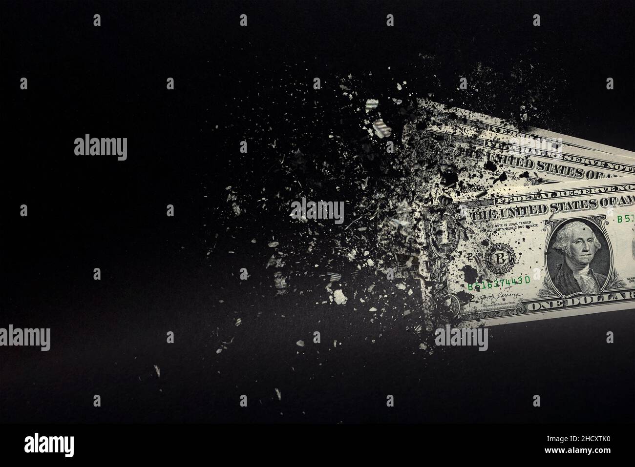 Spend money, spend all your money illiterately. The dollar bill turns to ash, dissolves against a black background. Place for text Stock Photo