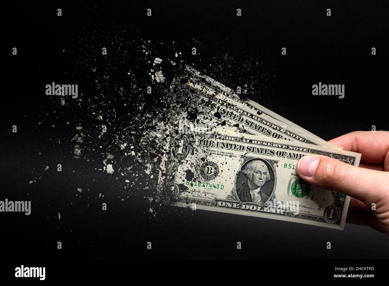 Inflation, dollar hyperinflation with black background. One dollar bill is sprayed in the hand of a man on a black background. The concept of decreasi Stock Photo