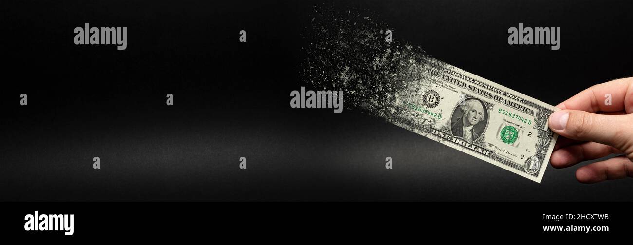 Inflation, dollar hyperinflation. Banner with black background. One dollar bill is sprayed in the hand of a man on a black background. The concept of Stock Photo