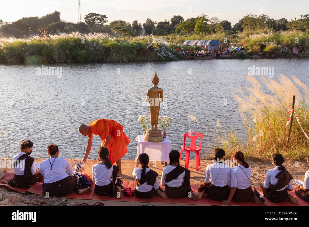 Mae Sot District, Thailand. 01st Jan, 2022. A Thai monk is seen leading prayers for Karen people. Evacuated Karen people live at a temporary campsite along Moei River on Myanmar's side which can be seen from Thailand's side around Mae Sot district. They have been living here for around 3 weeks after the conflict between Myanmar's military and KNU army (Karen National Union) in Myanmar's Karen State. Credit: SOPA Images Limited/Alamy Live News Stock Photo