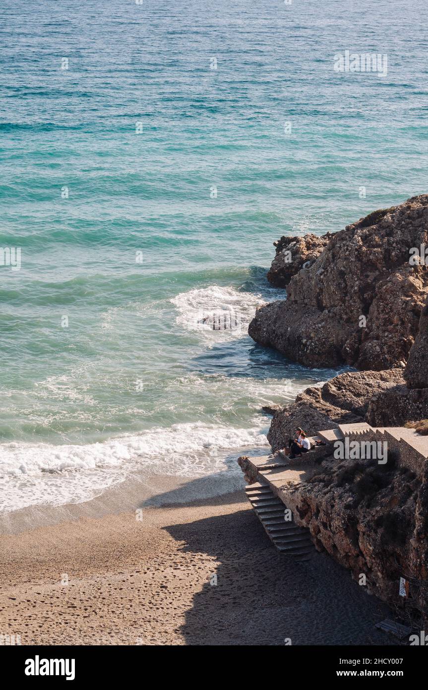 Aerial top view of sea waves hitting rocks on the beach with turquoise ...