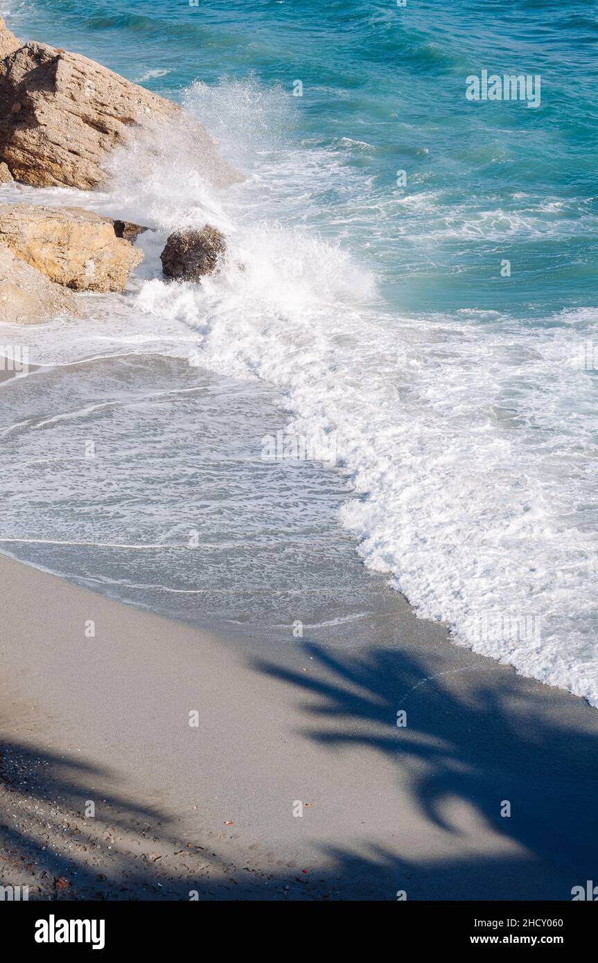 Aerial top view of sea waves hitting rocks on the beach with turquoise ...