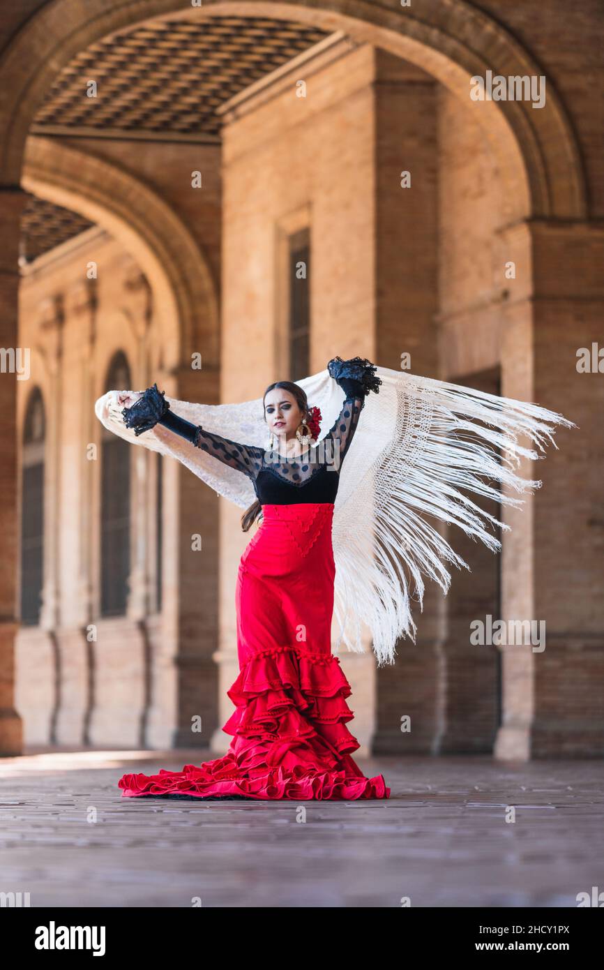 Woman in flamenco dress dancing while waving a cloth outdoors Stock Photo