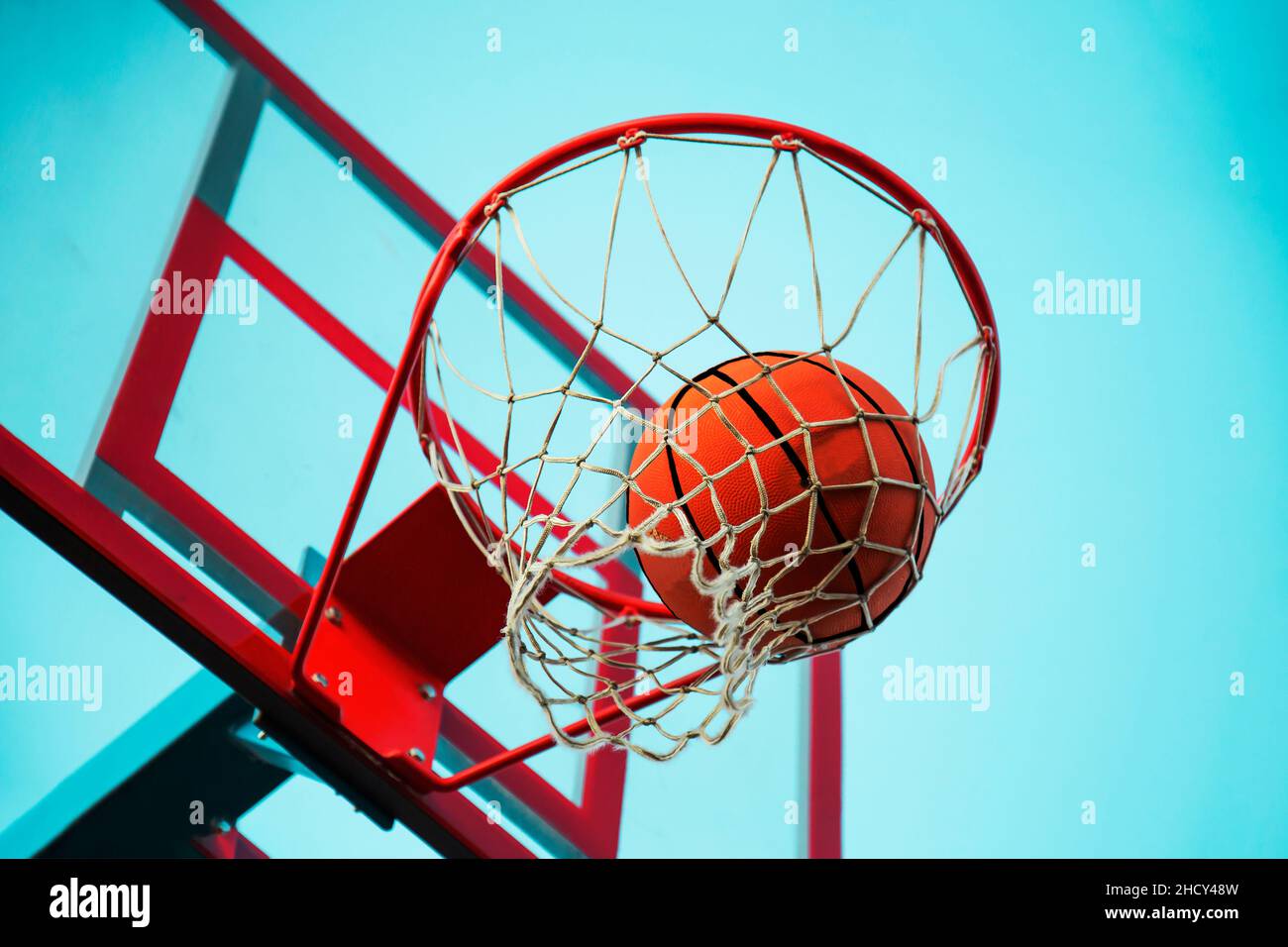 A basketball in the net. The fly ball is in the ring. A sports game