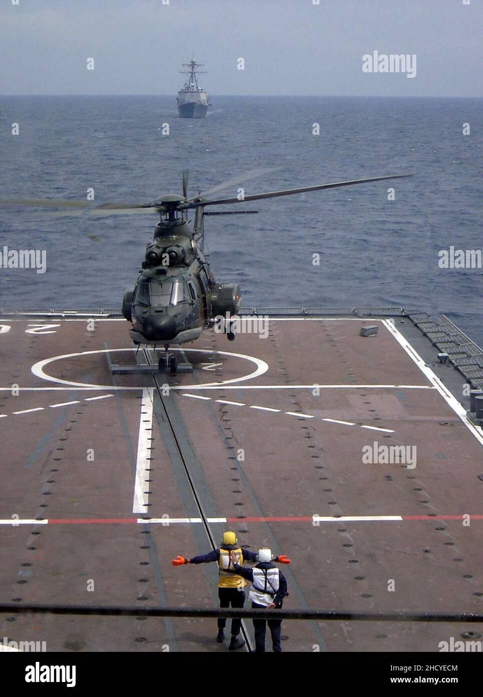 Republic of Singapore Air Force Eurocopter AS332 Super Puma taking off from the RSS Resolution with the USS Russell on the horizon - 20040607. Stock Photo