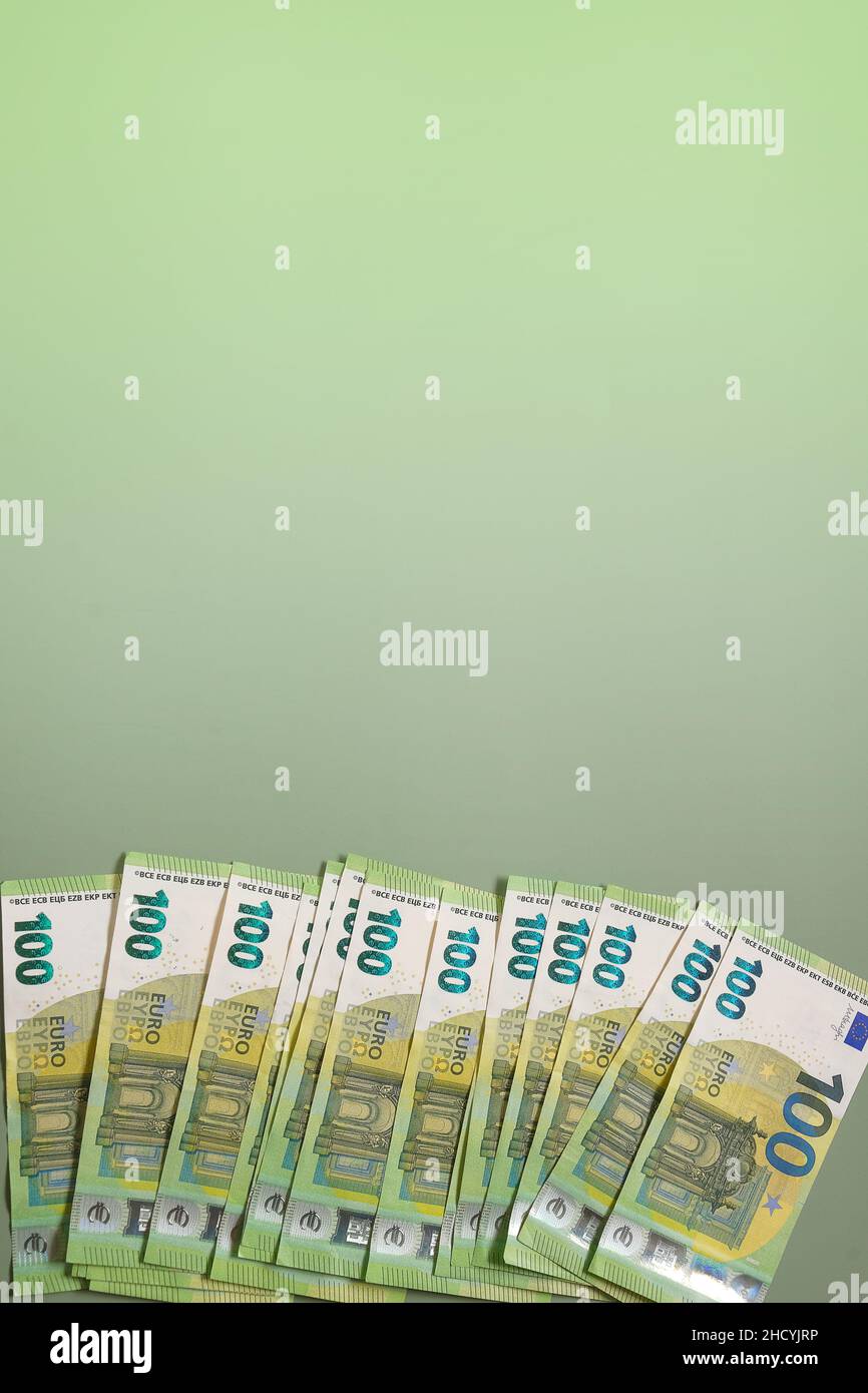 Euro currency.Money and finance. One hundred euro banknotes on a green background.euro banknotes bundle on a green background. Stock Photo