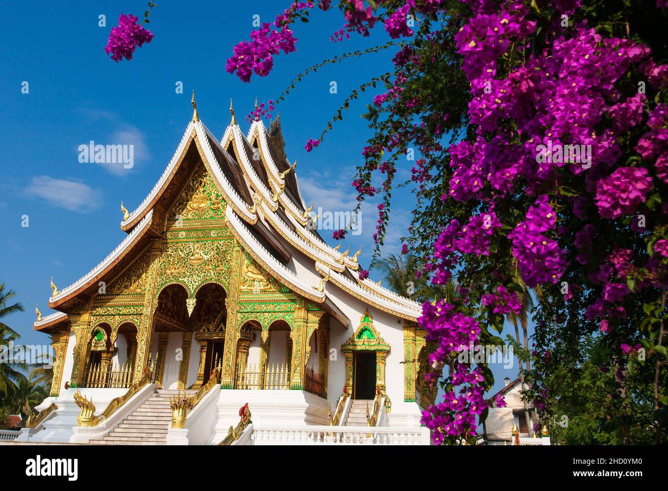 Picturesque exterior of the Royal Palace Museum of Luang Prabang, blooming Bougainvillea flowers in the foreground. Tourist attractions in Laos. Stock Photo