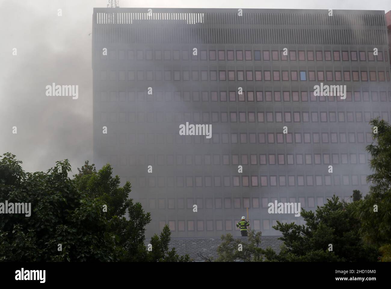 A fireman stands on the roof of the parliament where a fire broke out in Cape Town, South Africa, January 2, 2022. REUTERS/Mike Hutchings Stock Photo