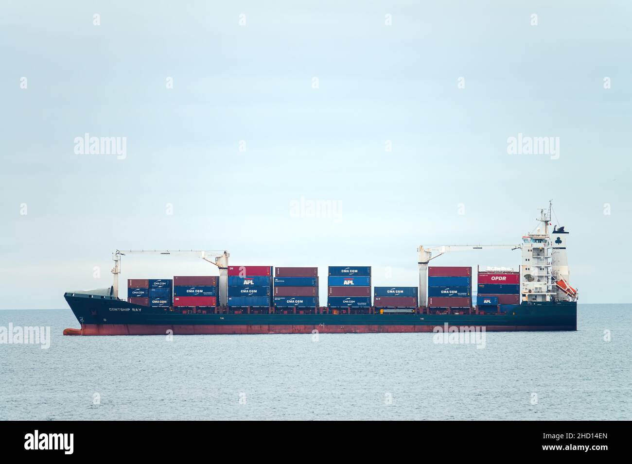 Container cargo ship, profile view, transport of shipping goods. Genova Italy - December 2021 Stock Photo