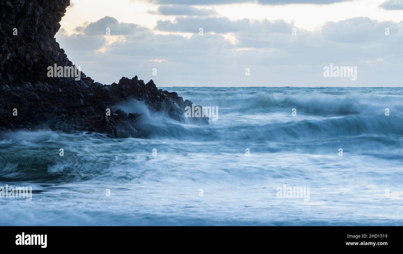 Huge waves crashing against the rocks at Piha beach, Auckland, New Zealand. Stock Photo