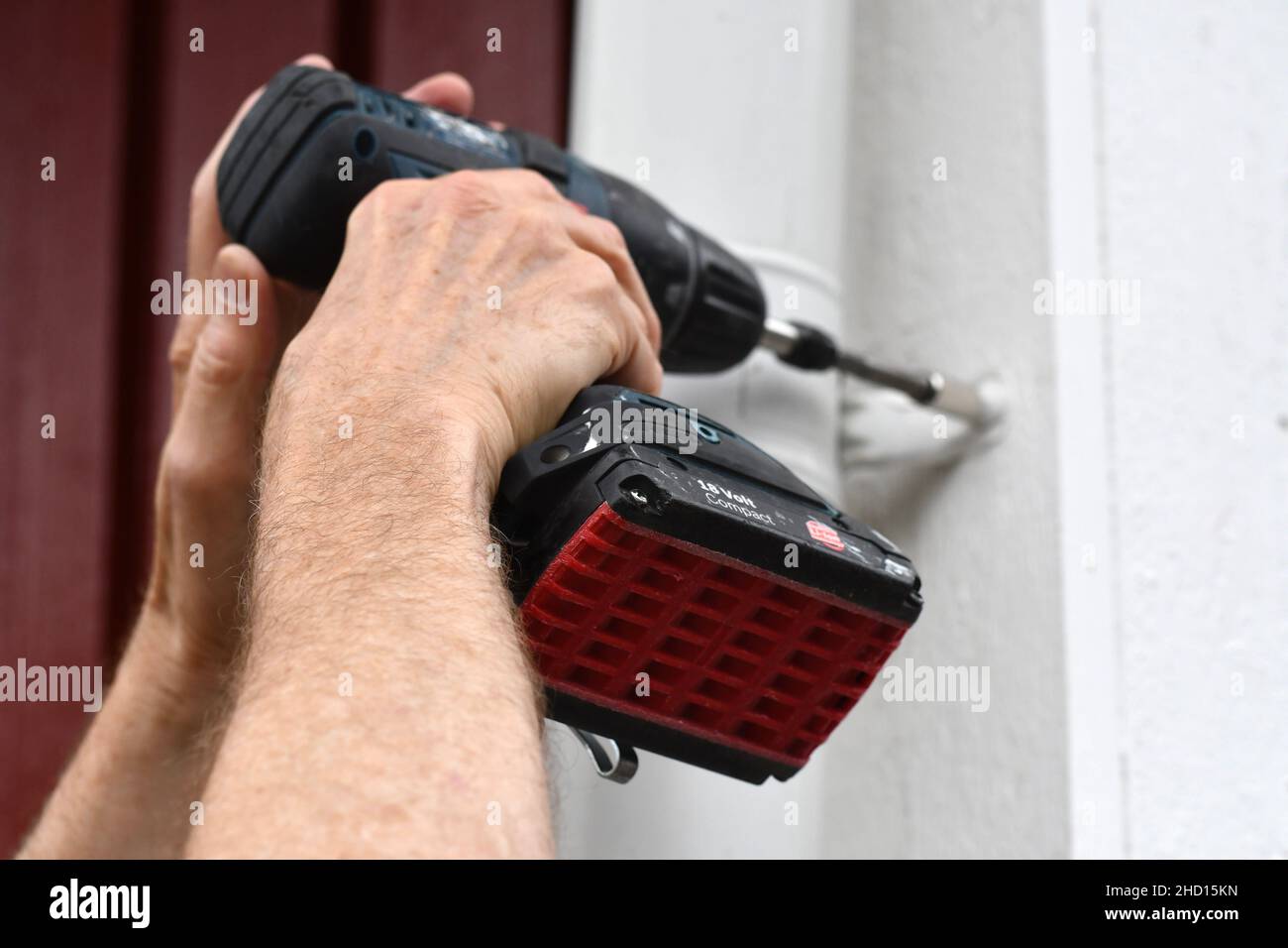 A man using a screwdriver machine to improve the house Stock Photo