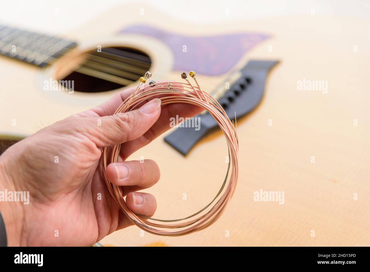 The musician replace the new guitar strings for his guitar Stock Photo