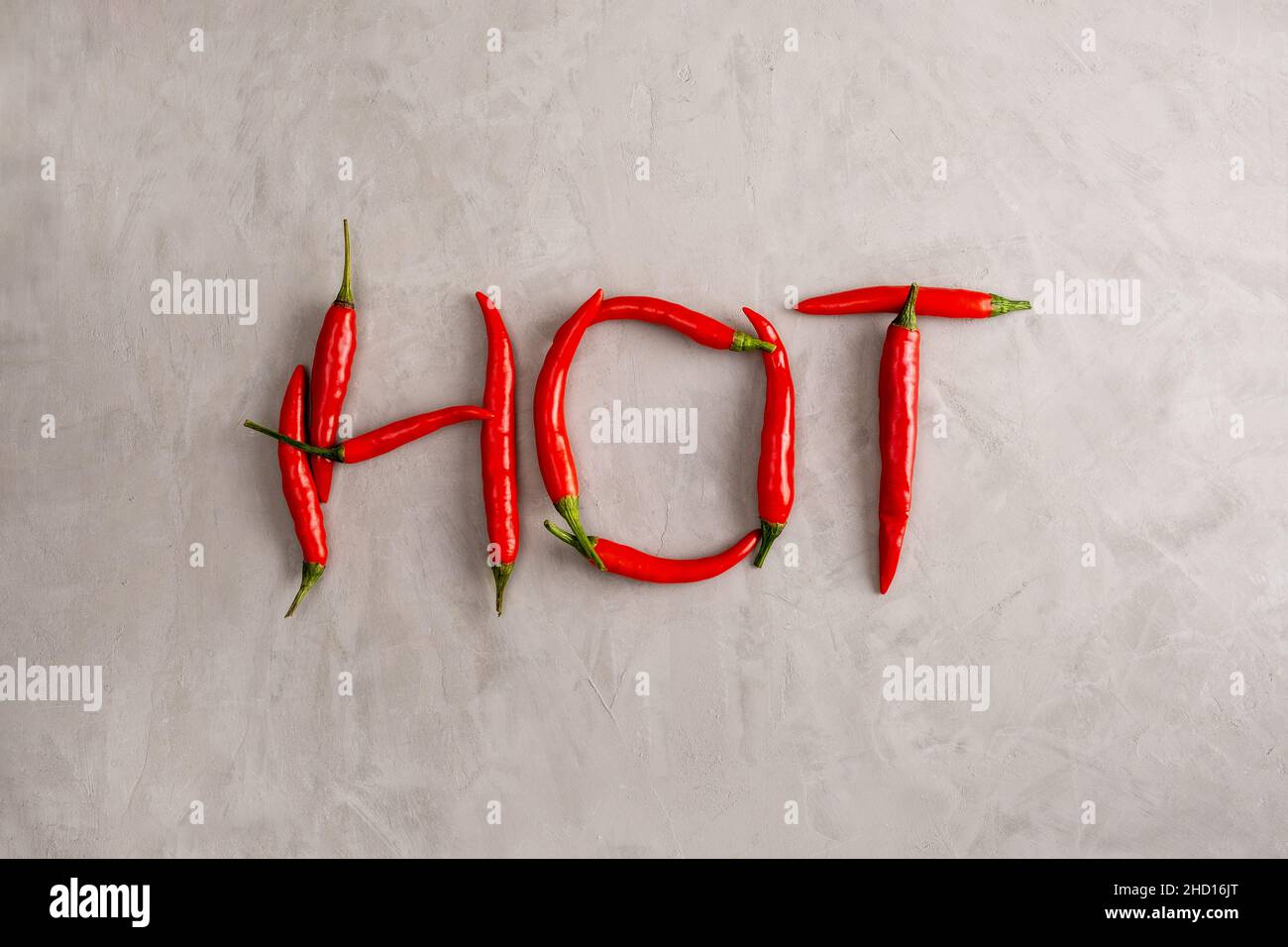 HOT lettering is lined with pods of red hot chili peppers on gray ...