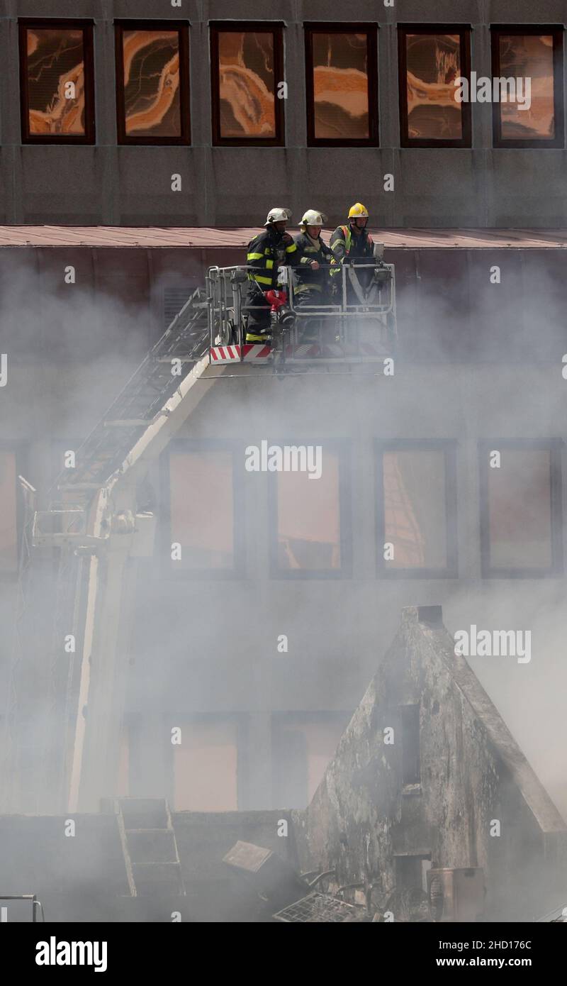 Firemen survey the damage after a fire broke out at the parliament in Cape Town, South Africa, January 2, 2022. REUTERS/Mike Hutchings Stock Photo