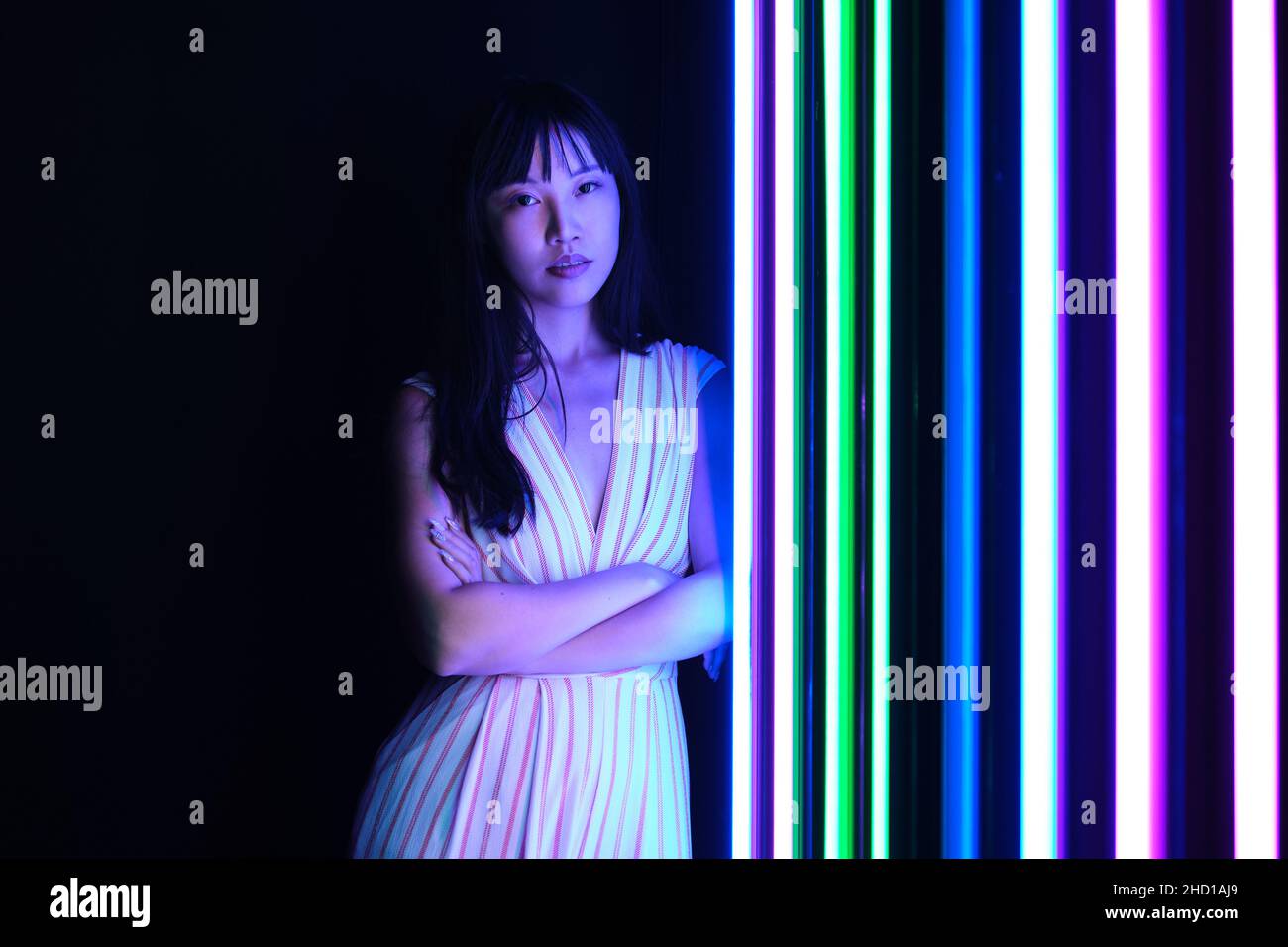 Young asian woman pose with colorful bright neon lights in studio. Stock Photo
