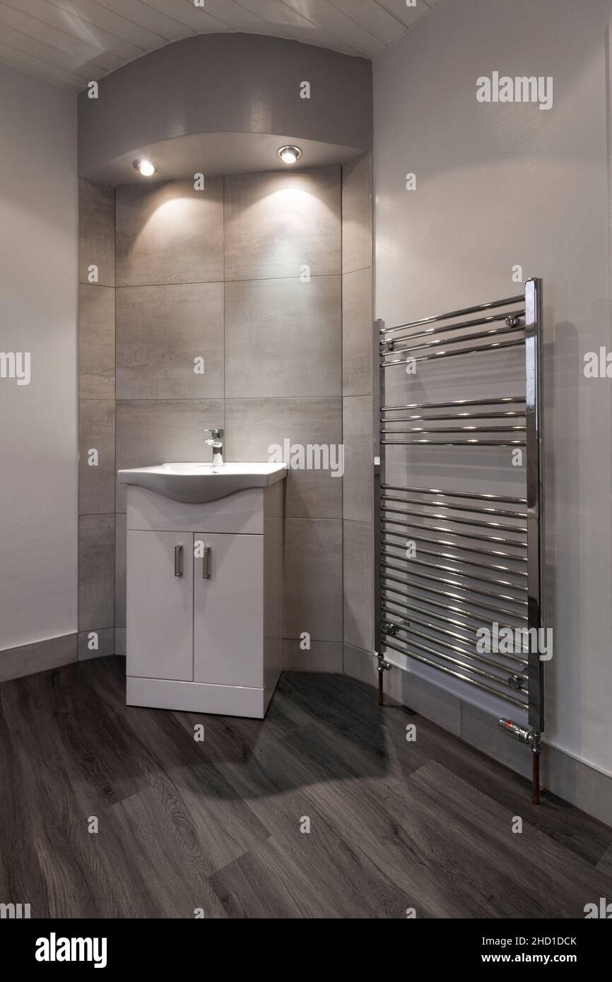 Modern bathroom with vanity unit, large Barrington white tiles, LVT vinyl flooring grey and
