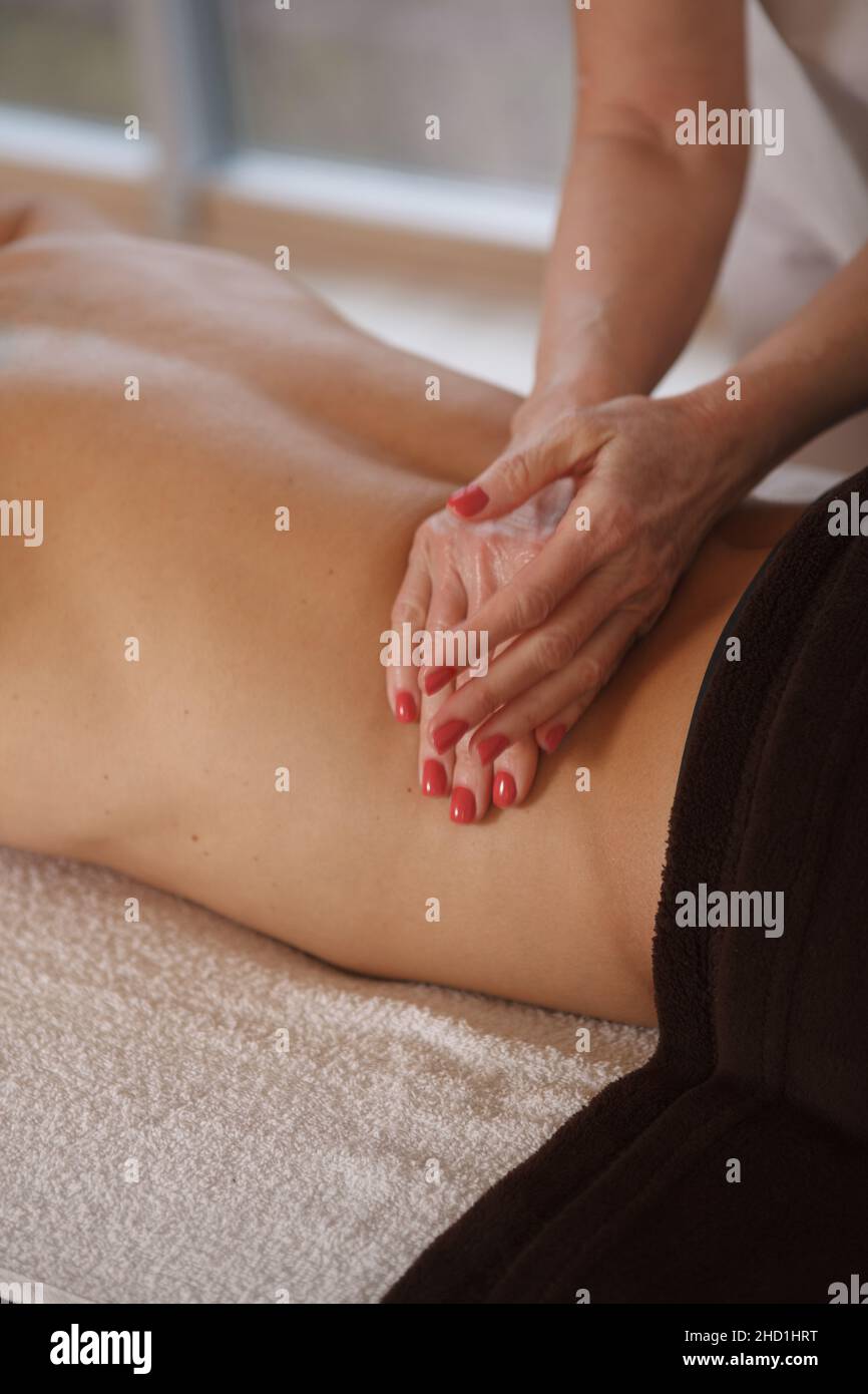 Unrecognizable professional masseur massaging back of a client Stock Photo